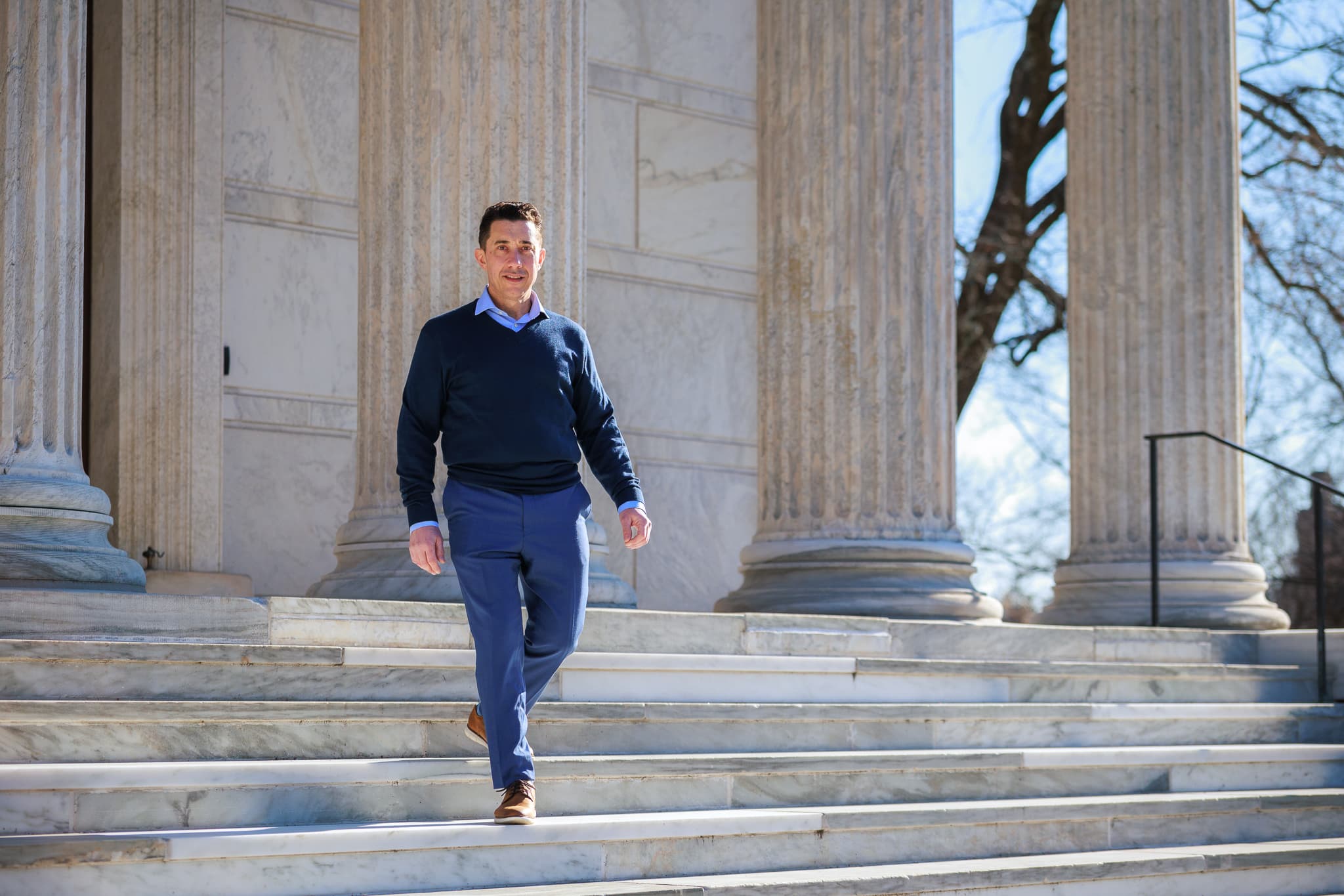 Frank Traina walking down the steps of a colonnade